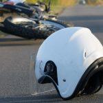 Photo of helmet and motorcycle on the road, the concept of road accidents