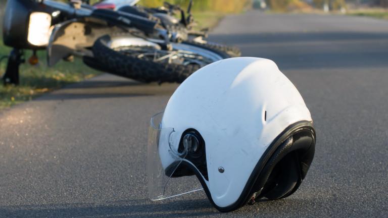 Photo of helmet and motorcycle on the road, the concept of road accidents