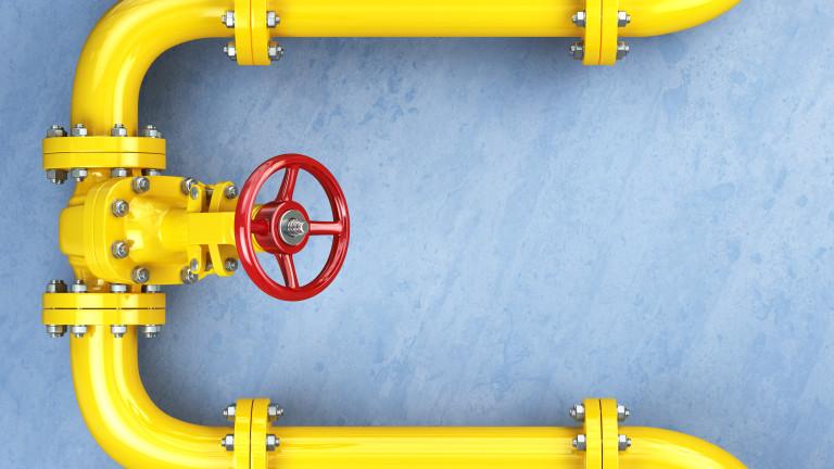 Yellow gas pipeline valve on a blue wall.