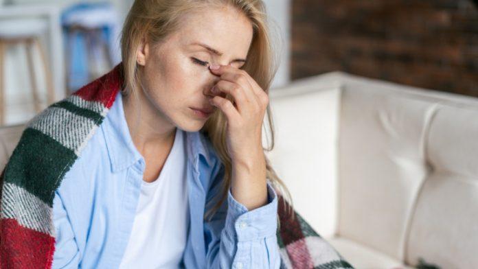 Tired woman with closed eyes touching nose bridge Tired woman with closed eyes touching nose bridge