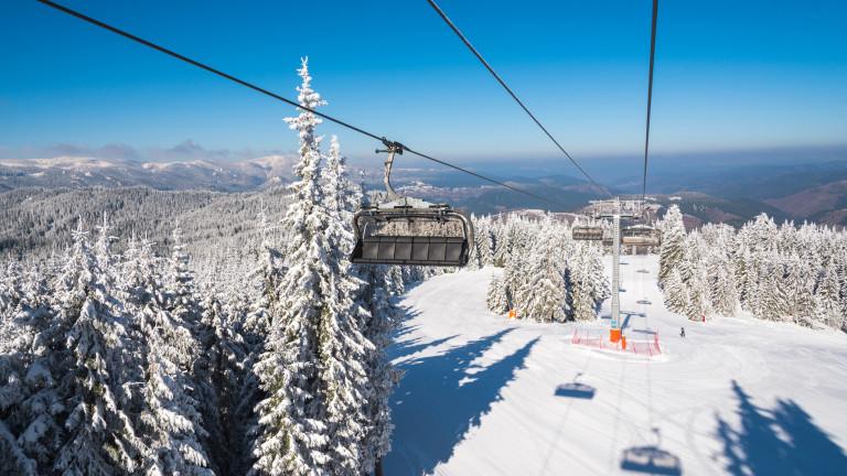 Ski lift with seats going over the mountain and ski tracks