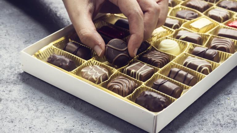 woman hand holding a chocolate piece from various type in box for valentine's day