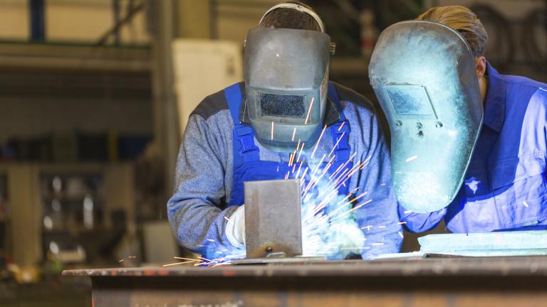 Two steel construction workers welding metal