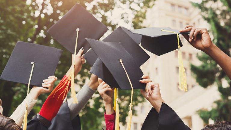 A group of graduates throwing graduation caps in the air