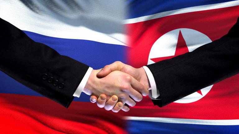 Russia and North Korea handshake, international friendship, flag background