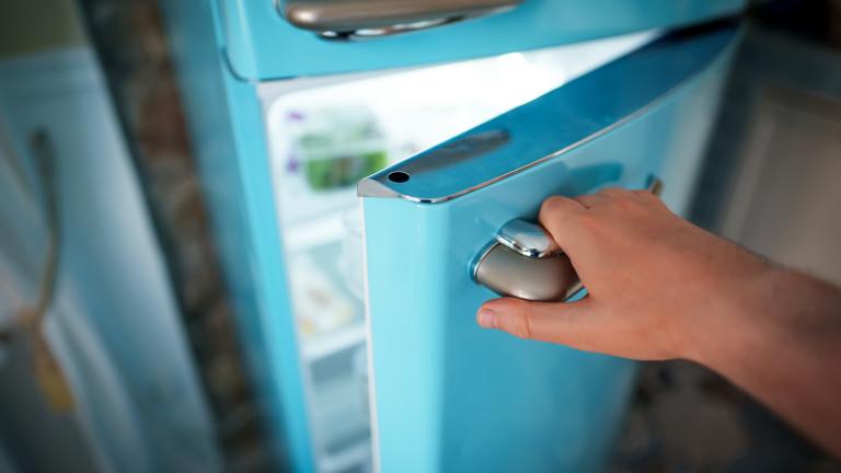 Man opening door of retro refrigerator freezer.